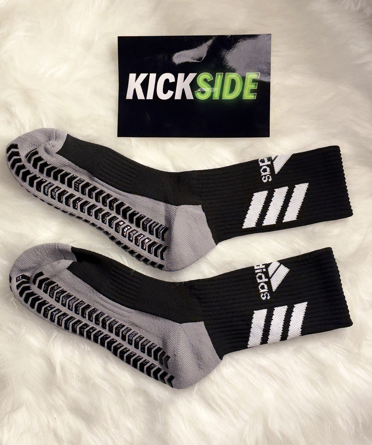 Pair of black football grip socks with grey sole and grip pads