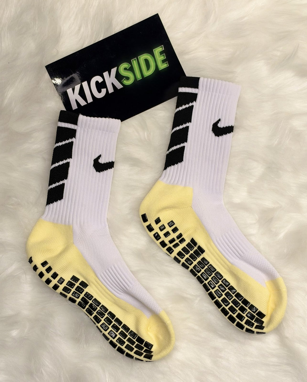 Pair of white football grip socks with yellow sole and black rubber grips